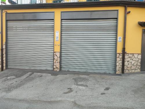 two metal garage doors on the side of a building at La corte del Campo in Cava deʼ Tirreni