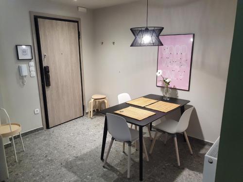 a dining room with a table and white chairs at GREEN HOUSE in Kardítsa