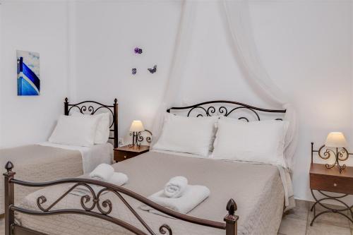a bedroom with two beds with white sheets and towels at Anemousa Studios in Otzias
