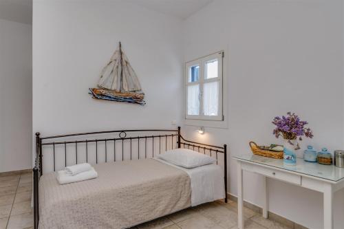 a bedroom with a bed and a table with a boat on the wall at Anemousa Studios in Otzias