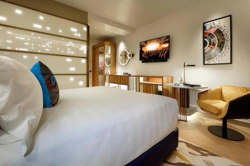 1 dormitorio con 1 cama blanca grande y 1 silla en Hard Rock Hotel Madrid, en Madrid