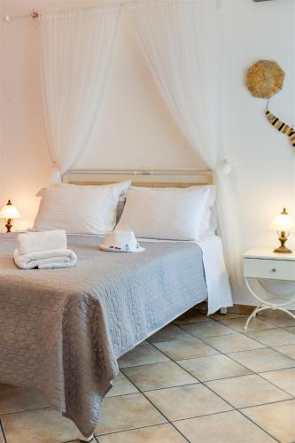 a bedroom with a bed with white sheets and pillows at Anemousa Studios in Otzias