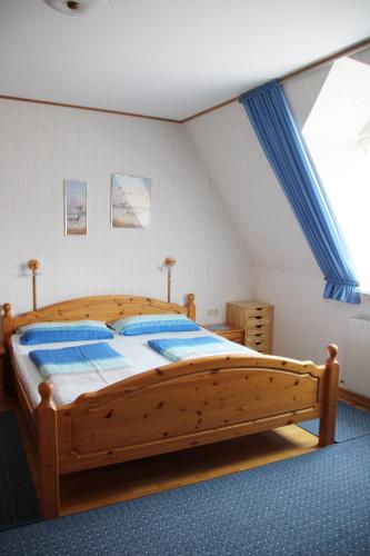 Cama grande de madera en habitación con ventana en Haus Beate, en Illmitz