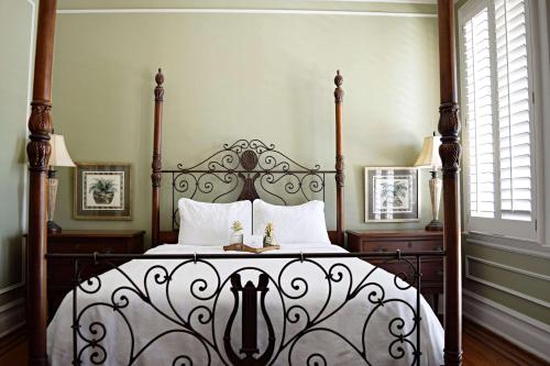 a bedroom with a black and white bed with white pillows at JH Adams Inn, Trademark Collection by Wyndham in High Point