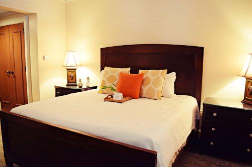 a bedroom with a large bed with orange and white pillows at JH Adams Inn, Trademark Collection by Wyndham in High Point