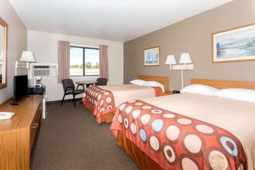 a hotel room with two beds and a desk at Super 8 by Wyndham Cos/Hwy. 24 E/PAFB Area in Cimarron Hills