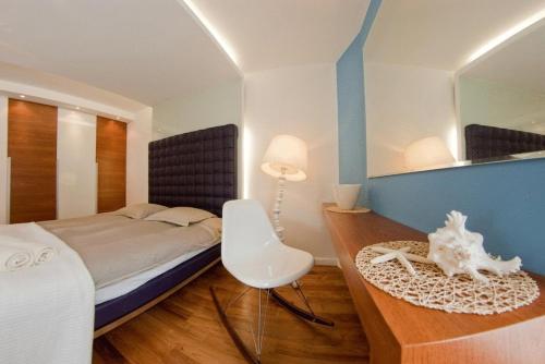 Un dormitorio con una cama, una mesa y un espejo. en Nadmorski Park, en Jastarnia