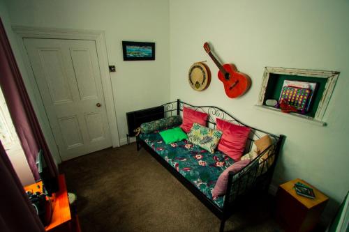 a living room with a couch and a guitar on the wall at Easkey Hostel in Sligo
