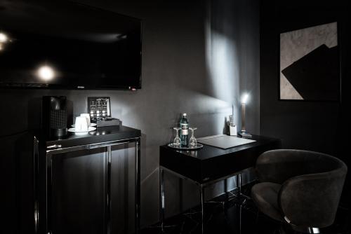 a black room with a desk and a chair at Hotel Belmont Classic in Bonn