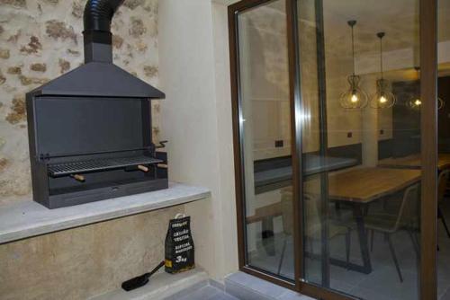 a stove in a kitchen with a table and a glass window at Mochoruralhome lonja b in Beceite