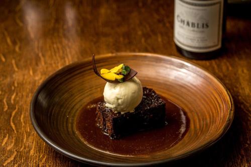a plate with a piece of chocolate dessert with whipped cream at The Queen's Arms in Hungerford
