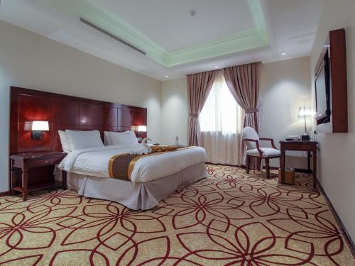 una camera d'albergo con un letto grande e una scrivania di Seafront Hotel Al Shatea a Gedda