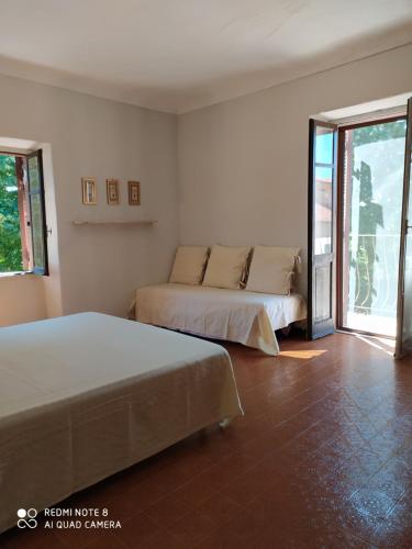 a bedroom with two beds and a balcony at Agriturismo Podere Luciano in Acqui Terme