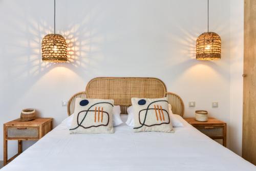 um quarto com uma cama branca e 2 almofadas em CMG Cozy appartement Juan-Les-Pins / 200m Plage em Antibes