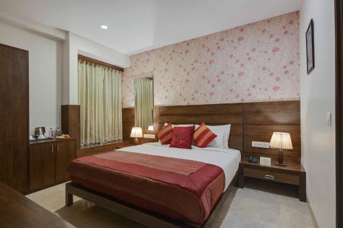 a bedroom with a bed with a red blanket at Shahpura Residency in Jaipur