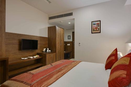 a bedroom with a large bed with a television at Shahpura Residency in Jaipur