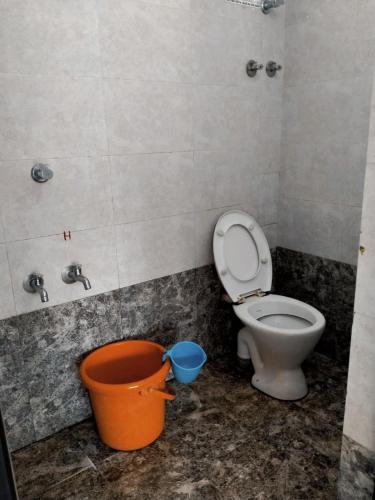 a bathroom with a toilet and a bucket at Hotel GANANJAYA in Gokarna