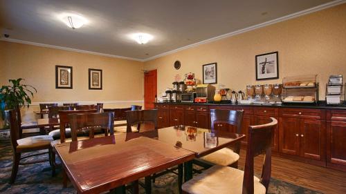 a restaurant with wooden tables and chairs and a counter at Best Western Queens Court in Queens