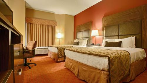 a hotel room with two beds and a television at Best Western Plus Tulsa Woodland Hills Hotel and Suites in Tulsa
