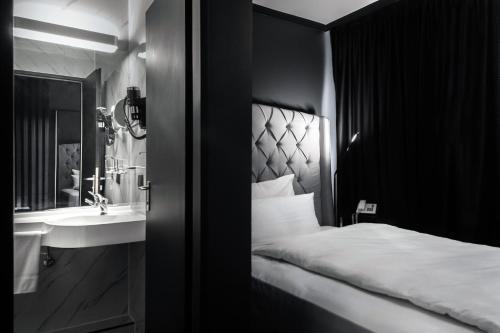 a hotel room with a bed and a sink at Hotel Belmont Classic in Bonn