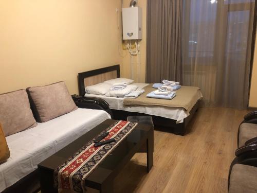a hotel room with two beds and a couch at Уютная квартира в центре in Yerevan