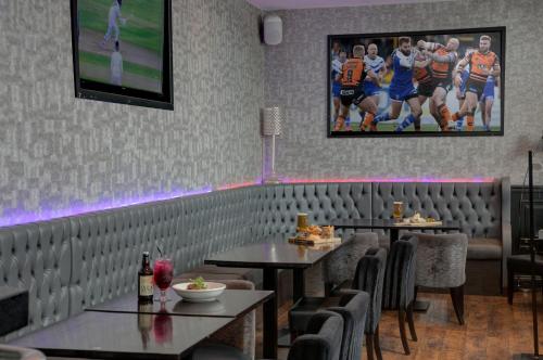 a dining room with two tables and chairs and a tv at The Eccleston Hotel; BW Signature Collection in Saint Helens