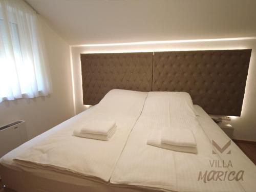 a large white bed with two white towels on it at Villa Marica Šipovo in Šipovo