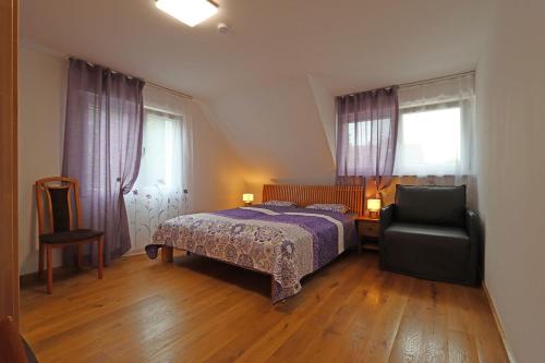 una camera da letto con un letto e una sedia di Adel FeWo am Herzzentrum a Bad Krozingen
