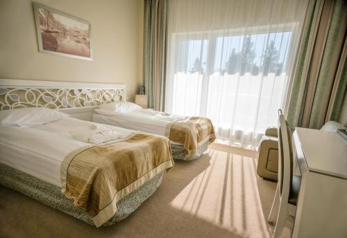 a hotel room with two beds and a window at Noorus SPA Hotel in Narva-Jõesuu