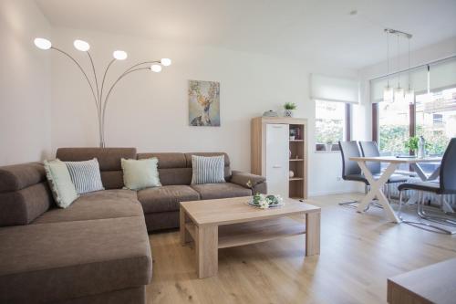 a living room with a couch and a table at Welcome in - Ferienwohnung 59-W in Winterberg mit Balkon und Schwimmbad in Winterberg