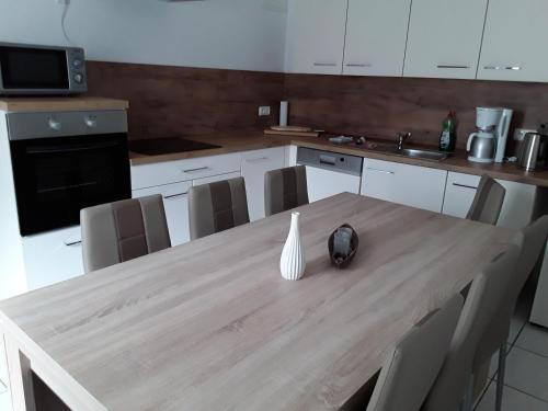 a kitchen with a wooden table with a vase on it at Pension Kaiser in Haldensleben