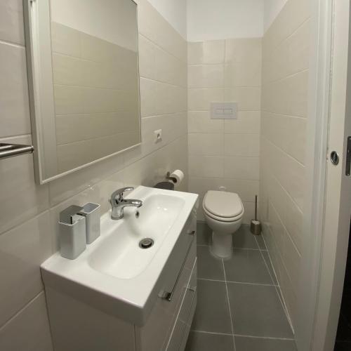 a white bathroom with a sink and a toilet at Casa Vita Scilla in Scilla