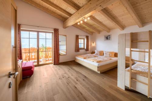 a bedroom with a bed and a balcony at Ferienwohnung Alpschwendthof in Mittersill