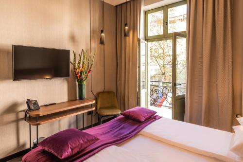 a hotel room with a bed and a desk and a window at Liebeskind Boutique Hotel Old Town in Kraków