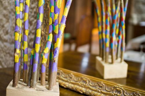 a group ofcolored wooden sticks in front of a mirror at Hotel O Portelo Rural in Allariz