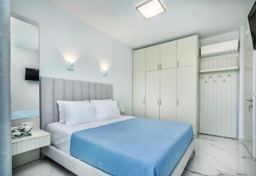 a bedroom with a blue bed and white cabinets at Beach Front Casa Elena in Hanioti
