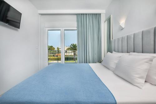 a bedroom with a large bed with a large window at Beach Front Casa Elena in Hanioti