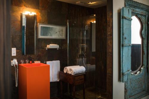 a bathroom with a red sink and a mirror at La Mare aux Oiseaux, The Originals Collection in Saint-Joachim