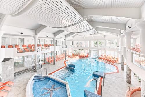 an indoor swimming pool with a large swimming poolvisor at Hotel Europa Fit Hévíz in Hévíz