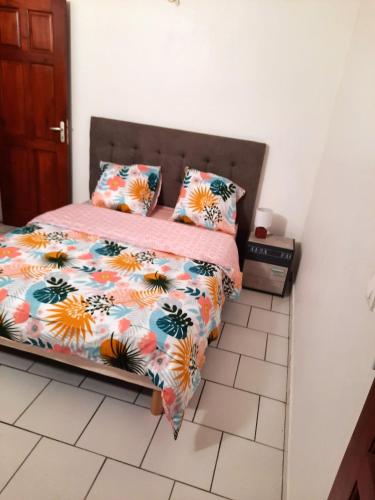 - une chambre avec un lit doté de draps et d'oreillers colorés dans l'établissement Maison charmante à Pointe-Noire avec vue mer, à Pointe-Noire