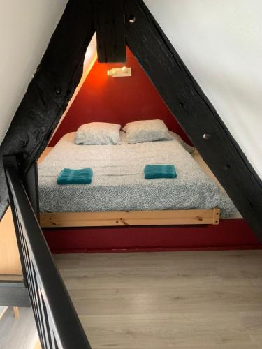 a bed with two pillows on it in a attic at Le bas-sablons in Saint Malo