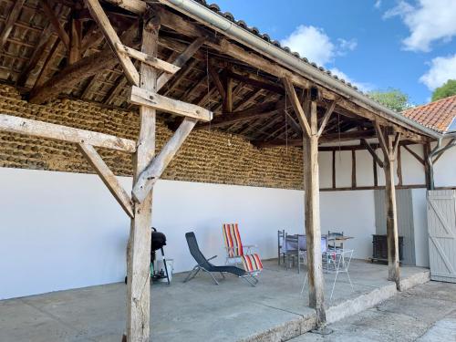 a wooden pavilion with chairs and a table at Chez Mima in Samadet