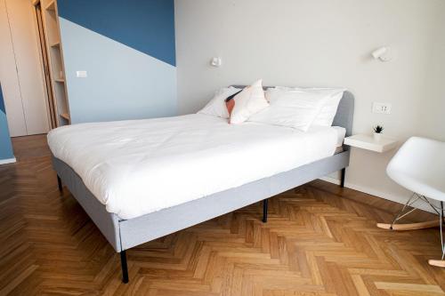 a bed with white sheets and pillows in a room at Marconi 442 in Sanremo