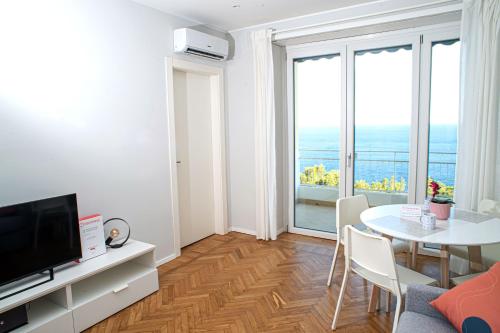 a living room with a table and a large window at Marconi 442 in Sanremo