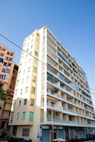 a tall white apartment building with balconies at Marconi 442 in Sanremo