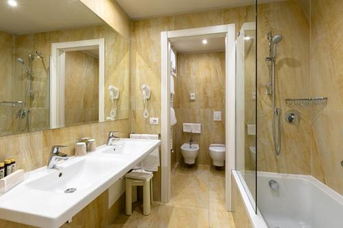 a bathroom with two sinks and a shower and a toilet at Du Parc in Sirmione