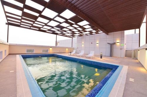 a large swimming pool in a building with a ceiling at Saray Deluxe Hotel Apartments in Abu Dhabi