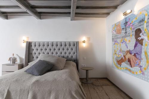a bedroom with a bed with a large painting on the wall at De Merin Boutique Hotel Straden in Straden