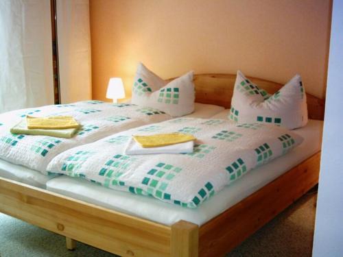 BermsgrünKlein aber fein - Apartment für 2 bis 4 Personen的一张配有白色和绿色床单及枕头的大床