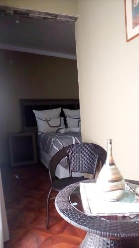 a bedroom with a bed and a table with a table at Authentic Bicycle Tours and Backpackers in Soweto